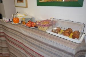 ミラノにあるホテル イリーデのパンと果物のトレイが入ったテーブル