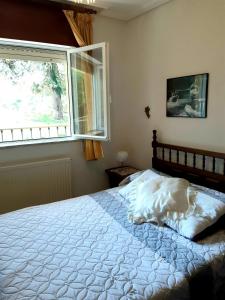 1 dormitorio con 1 cama blanca y ventana en La Choza de La Franca en La Franca