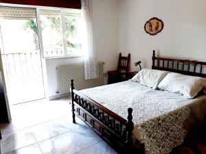 1 dormitorio con cama y ventana grande en La Choza de La Franca en La Franca