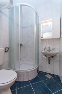 ein Bad mit einer Dusche, einem WC und einem Waschbecken in der Unterkunft Apartments and Rooms Nikola in Omiš