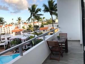 einen Balkon mit einem Tisch und Stühlen sowie Stadtblick in der Unterkunft DUCASSI-SOL CARIBE PUNTA CANA BAVARO Beach HOTEL in Punta Cana