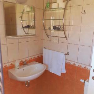 uma casa de banho com lavatório, espelho e toalhas em Petra Apartmanház em Kehidakustány