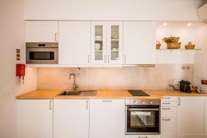 een keuken met witte kasten en een spoelbak bij 188 Apartments - Buganvília - pool and balcony in Cascais