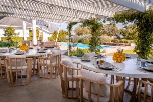 a patio with tables and chairs and a pool at The Dongola Guesthouse in Cape Town