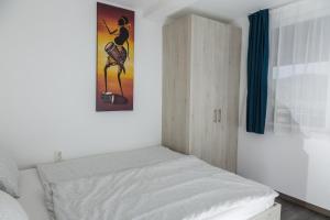 a small bedroom with a bed and a cabinet at Aranyos Hillside in Nagymaros