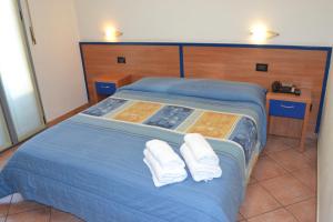 a blue bed with two white towels on it at Hotel Iride in Milan