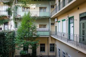 un immeuble d'appartements avec balcon et arbre dans l'établissement Stella Apartment, à Budapest