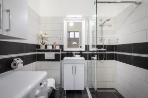 een witte badkamer met een douche en een wastafel bij Stella Apartment in Boedapest