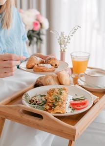 a woman sitting at a table with two plates of food at Moje Orłowo Boutique Bed & Breakfast - Adults Only in Gdynia