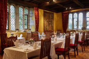 a dining room with white tables and chairs and windows at Bailiffscourt Hotel & Spa in Arundel