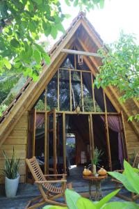 Cabaña con puerta de cristal y sillas en la parte delantera en Cinnamon Paradise en Ahangama