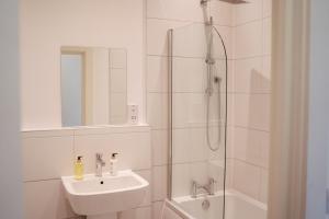 bagno bianco con lavandino e doccia di Apartment 8 2 bedrooms, sleeps x 6 a York