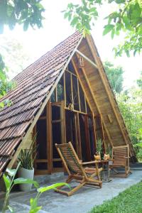 een klein huis met twee stoelen en een tafel bij Cinnamon Paradise in Ahangama