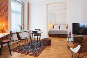 ハンブルクにあるAparthotel alsterSuiteのリビングルーム(ベッド1台、テーブル、椅子付)