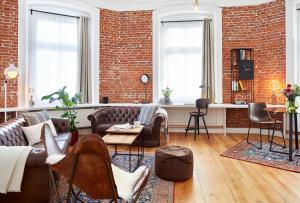 uma sala de estar com sofás e uma parede de tijolos em Aparthotel alsterSuite em Hamburgo