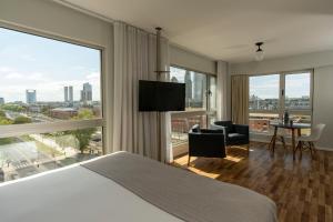 pokój hotelowy z łóżkiem i dużym oknem w obiekcie Almarena Madero Urbano w BuenosAires