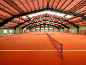 einen Indoor-Tennisplatz mit einem Netz in der Mitte in der Unterkunft Der Trattner - Hotel Trattnerhof & Hotel Schöcklblick in Semriach