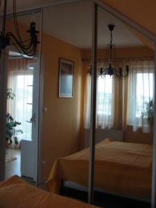 1 dormitorio con cama y espejo en Ferienwohnung, en Hévíz