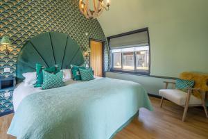 a bedroom with a large bed with a green headboard at The Nissen Hut at Green Valley Farm in Laxfield