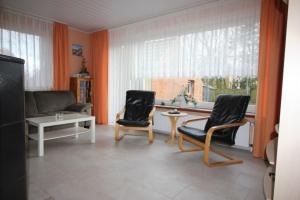 a living room with two chairs and a table and a window at Ferienhaus Brigitte in Dornum