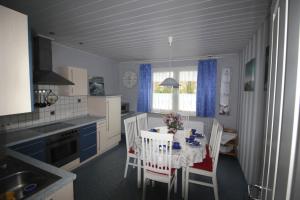 a kitchen with a table and chairs in a kitchen at Ferienhaus Brigitte in Dornum