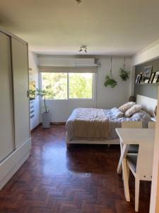 a bedroom with a bed and a table and a window at G3 Inn apartments in Mendoza