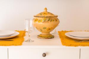 een vaas op een tafel met borden en een glas bij 188 Apartments - Buganvília - pool and balcony in Cascais