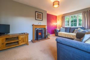 a living room with a couch and a fire place at Field End in Westleton