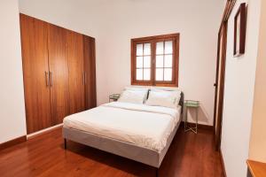 サンタクルス・デ・テネリフェにあるLarita's Houseのベッドルーム1室(ベッド1台付)、木製キャビネットが備わります。