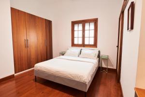 1 dormitorio con 1 cama y armario de madera en Larita's House, en Santa Cruz de Tenerife