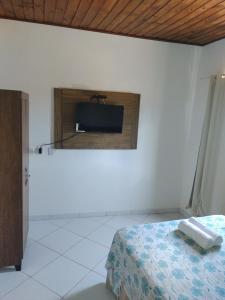 1 dormitorio con 1 cama y TV en la pared en Apartamentos em Pipa RN, en Pipa