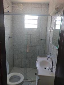 La salle de bains est pourvue d'une douche, de toilettes et d'un lavabo. dans l'établissement Apartamentos em Pipa RN, à Pipa