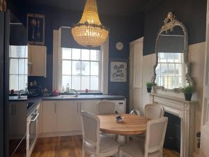 uma cozinha com mesa e cadeiras e um candelabro em Beautiful Seaview 2 Bedroom Apartment em Brighton & Hove