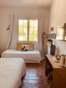 a bedroom with a bed and a window at Hotel de La Plage - Mahogany in Cassis