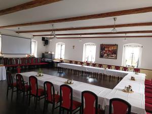 Penzion U Švarců في Zduchovice: قاعة اجتماعات مع طاولات وكراسي وشاشة