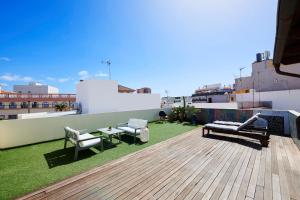 a rooftop patio with benches and tables on a building at Larita's House in Santa Cruz de Tenerife