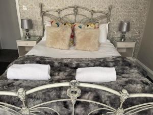 um quarto com uma cama com duas almofadas e toalhas em Beautiful Seaview 2 Bedroom Apartment em Brighton & Hove