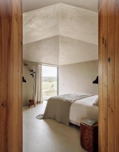 a bedroom with a large bed and a large window at Pa.te.os in Melides