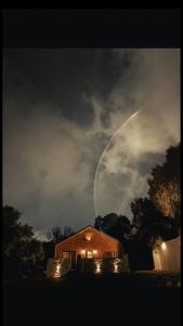 a house with a moon in the sky at night at كوخ البيلسان in Al Shafa