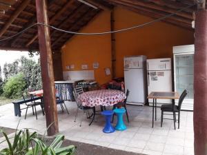 a patio with a table and chairs and appliances at Posada Los Arcos in Villa Cura Brochero