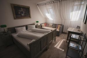 Penzion U Švarců في Zduchovice: غرفة نوم صغيرة مع سرير وأريكة