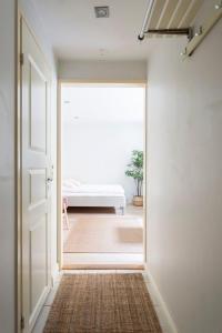 a hallway with a door leading to a room with a bed at 2ndhomes Cozy Studio in the City Center in Helsinki