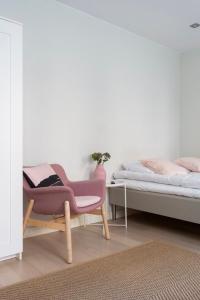 ヘルシンキにある2ndhomes Cozy Studio in the City Centerのベッドルーム1室(ベッド1台、ベッド横の椅子付)
