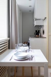 a kitchen table with a plate and glasses on it at 2ndhomes Cozy Studio in the City Center in Helsinki