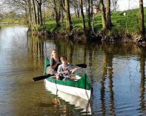 a woman and a boy in a canoe on a river at Ferienwohnungen Bekperle in Bekdorf