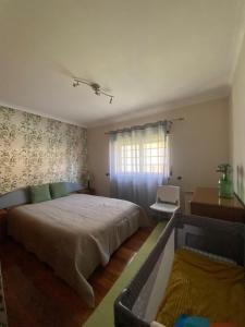a bedroom with a bed and a desk and a window at Quinta Casal da Eva in Alcobaça