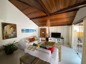a living room with two white couches and a wooden ceiling at Casa de praia tranquilidade e conforto in Búzios
