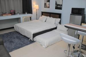 - une chambre avec 2 lits, une table et un bureau dans l'établissement A2J Executive Studio Suite Near Venice Mall BGC, à Manille
