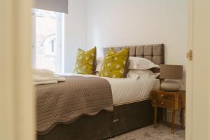 Un dormitorio con una cama con almohadas amarillas y una ventana en Apartment 1 2 bedrooms, sleeps x 6, en York