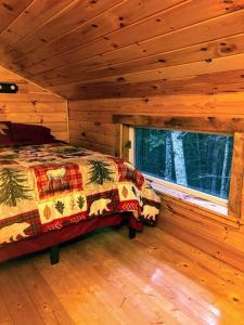 sypialnia z łóżkiem w drewnianym domku w obiekcie Vana Kuti-cabin in the woods w mieście Camden